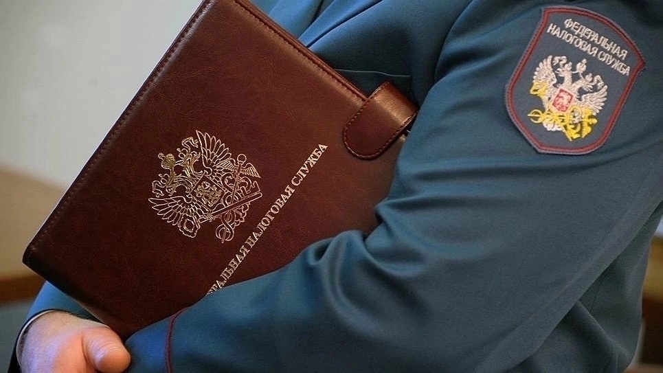    Сотрудник ФНС держит коричневый кожаный папка с гербом Главный редактор