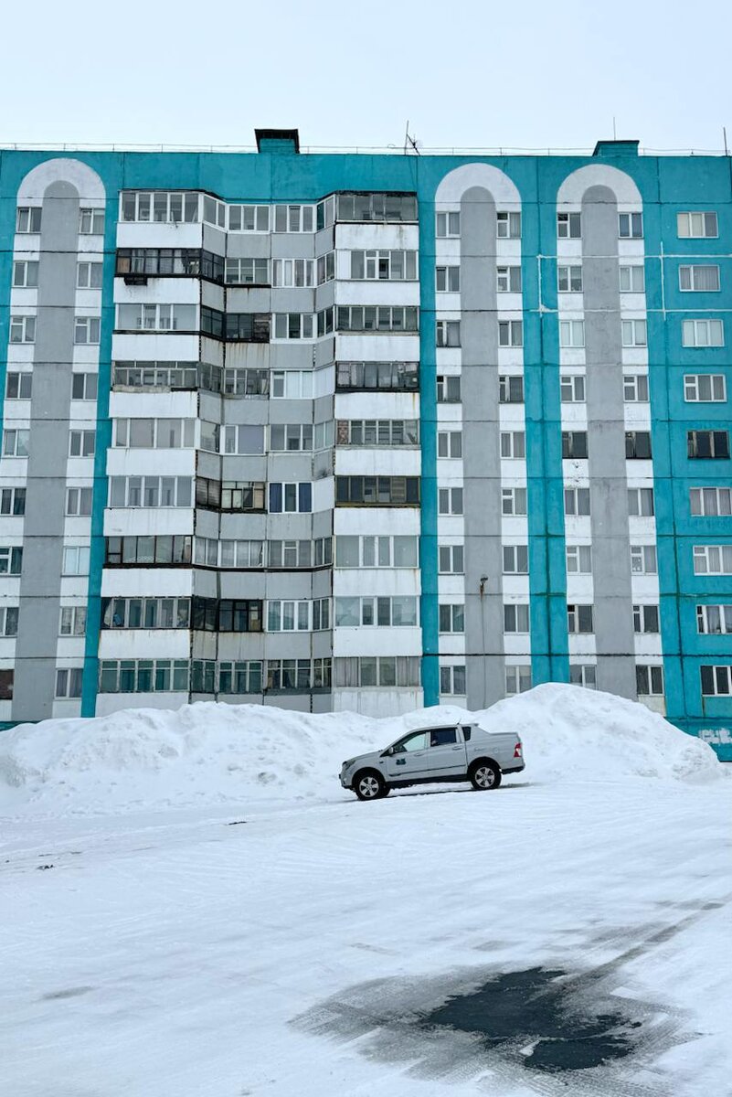 Цветные дома в Дудинке. Сугробы выше машин в апреле — норма для этого города.