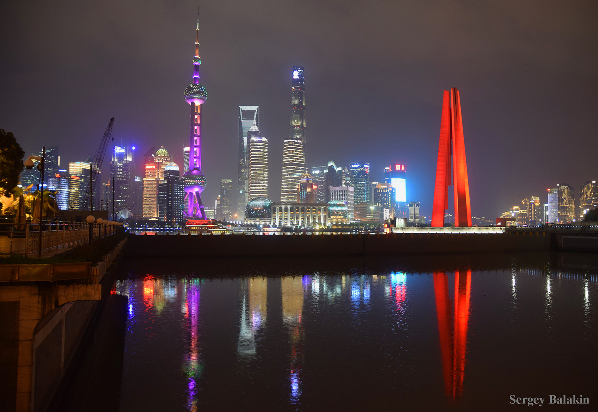 Вид с левого берега реки Хуанпу на устье притока Сучжоу, памятник борцам за свободу в красной подсветке и небоскрёбы правобережного района Пудун-Луцзяцзуй, март 2019 г. Здесь и далее все фото автора