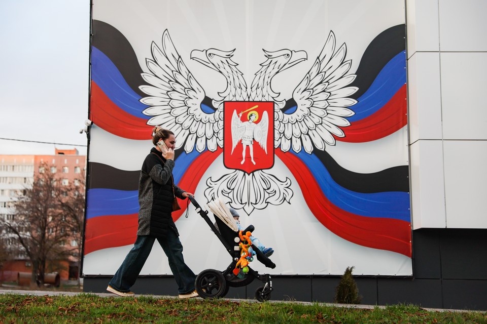    Женщина с коляской в жилом районе города Мариуполь, ДНР. Фото: Дмитрий Ягодкин/ТАСС