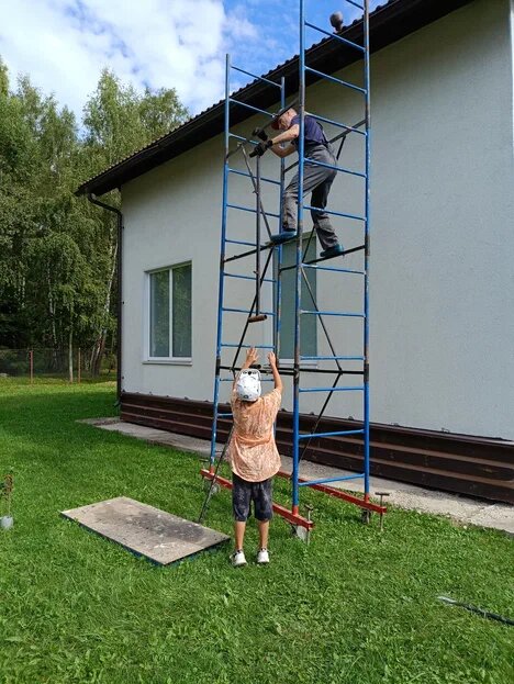 Дедушка с внуком занимаются ремонтом дома.