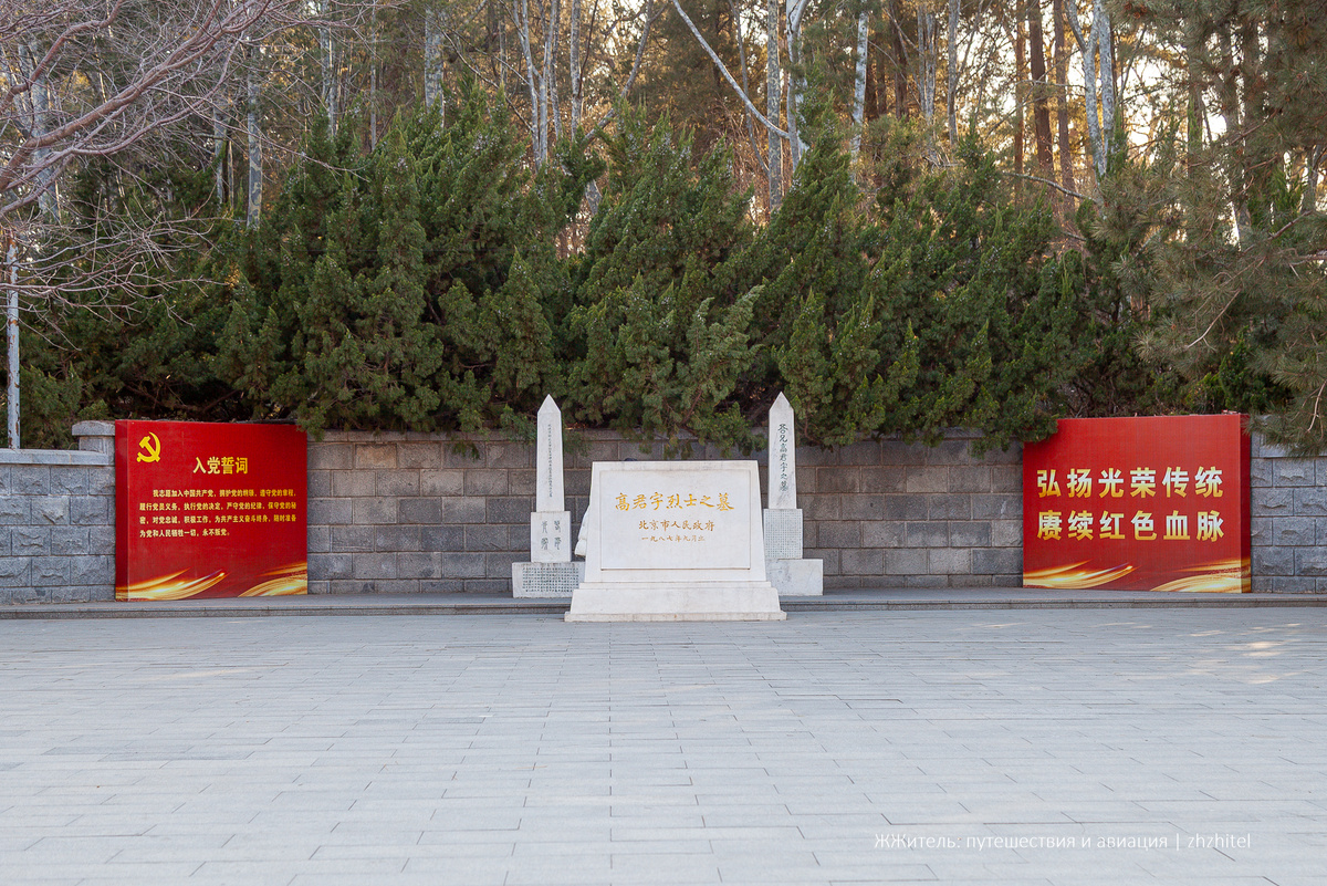 Монумент в парке. Слева — флаг с серпом и молотом