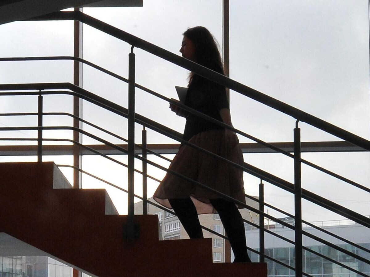    Девушка поднимается по лестнице в офисе | © РИА Новости / Сергей Кузнецов