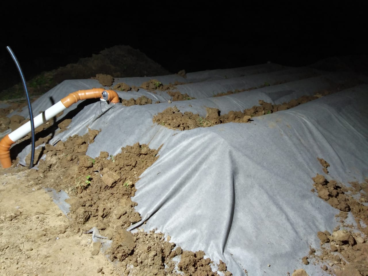 На фото видно напорную трубу ПНД подачи стоков (не подключена к распределительной гребенке поля) и воздушную линию связи септика с полем.