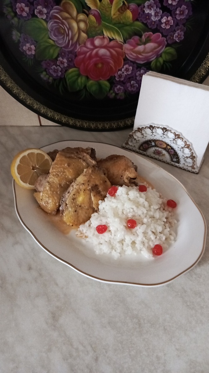 Тушёная кусочками курица с рисом на сервировочном блюде. Фото автора.