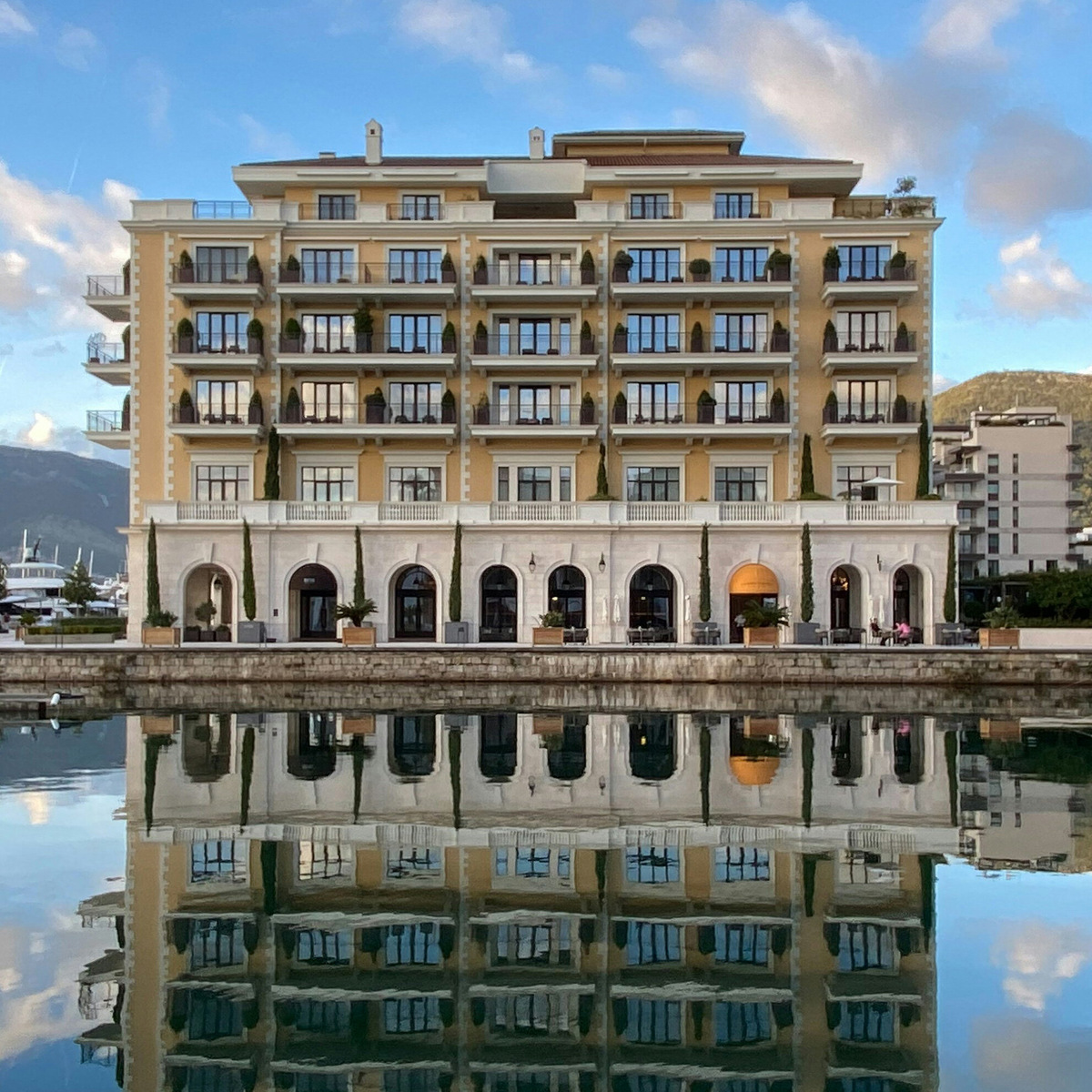 Узнаваемый вид Порто Монтенегро — здание пятизвёздочного отеля Regent, отражающееся в зеркальной глади воды. Фото: Linda Gerbec / Unsplash