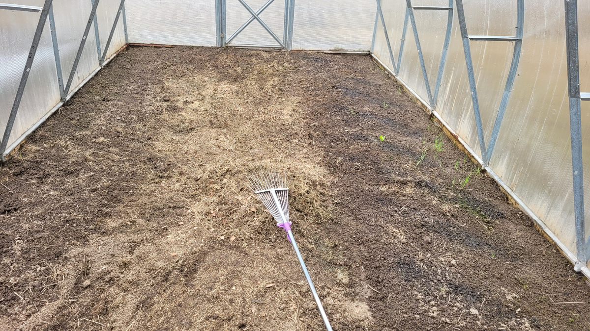 В центре под граблями кучка сена.