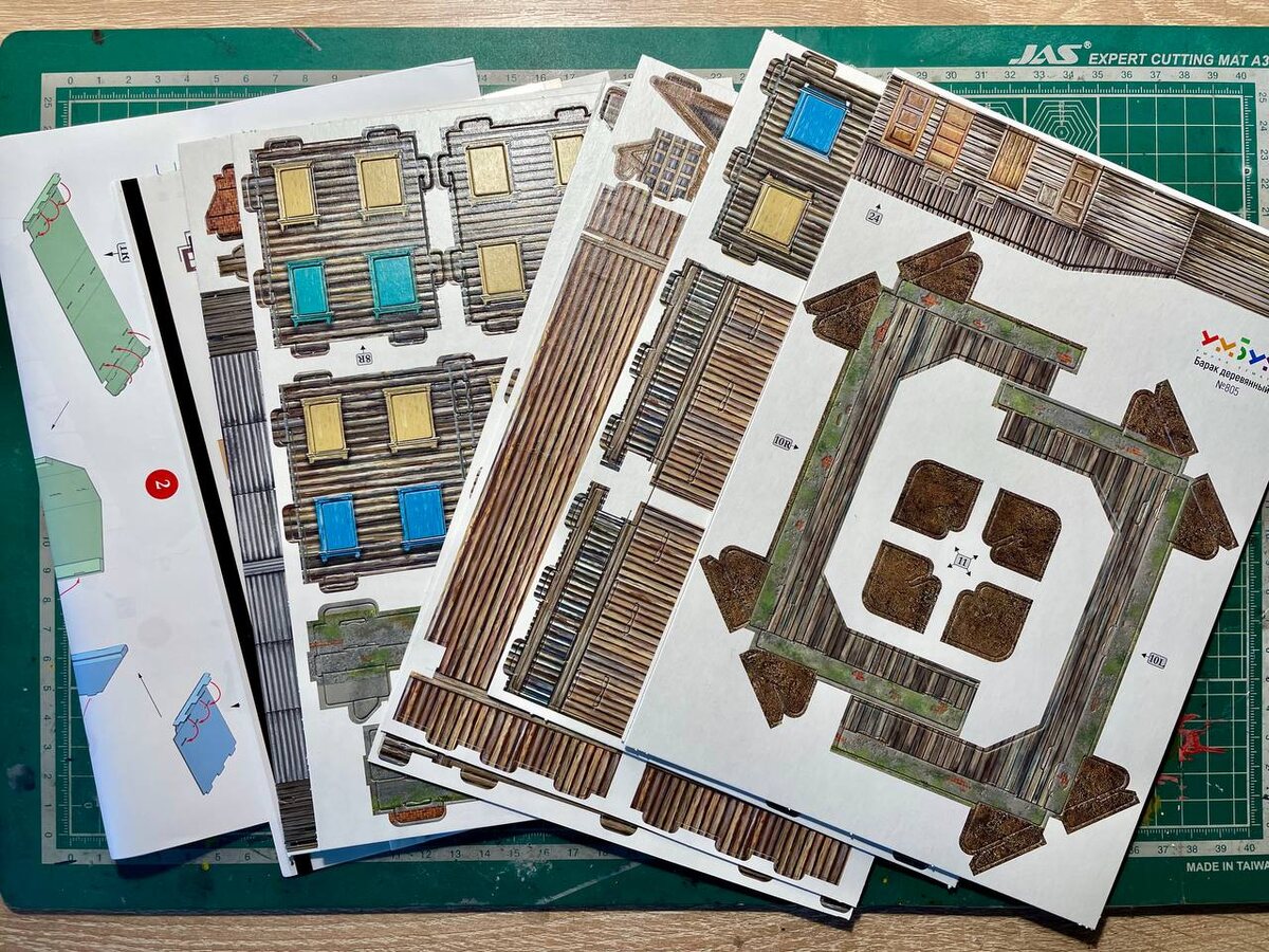 Содержимое набора выглядит так: цветные листы плотного картона, цветная инструкция и напечатанные на прозрачном листе из пластика окна на самоклейке. 