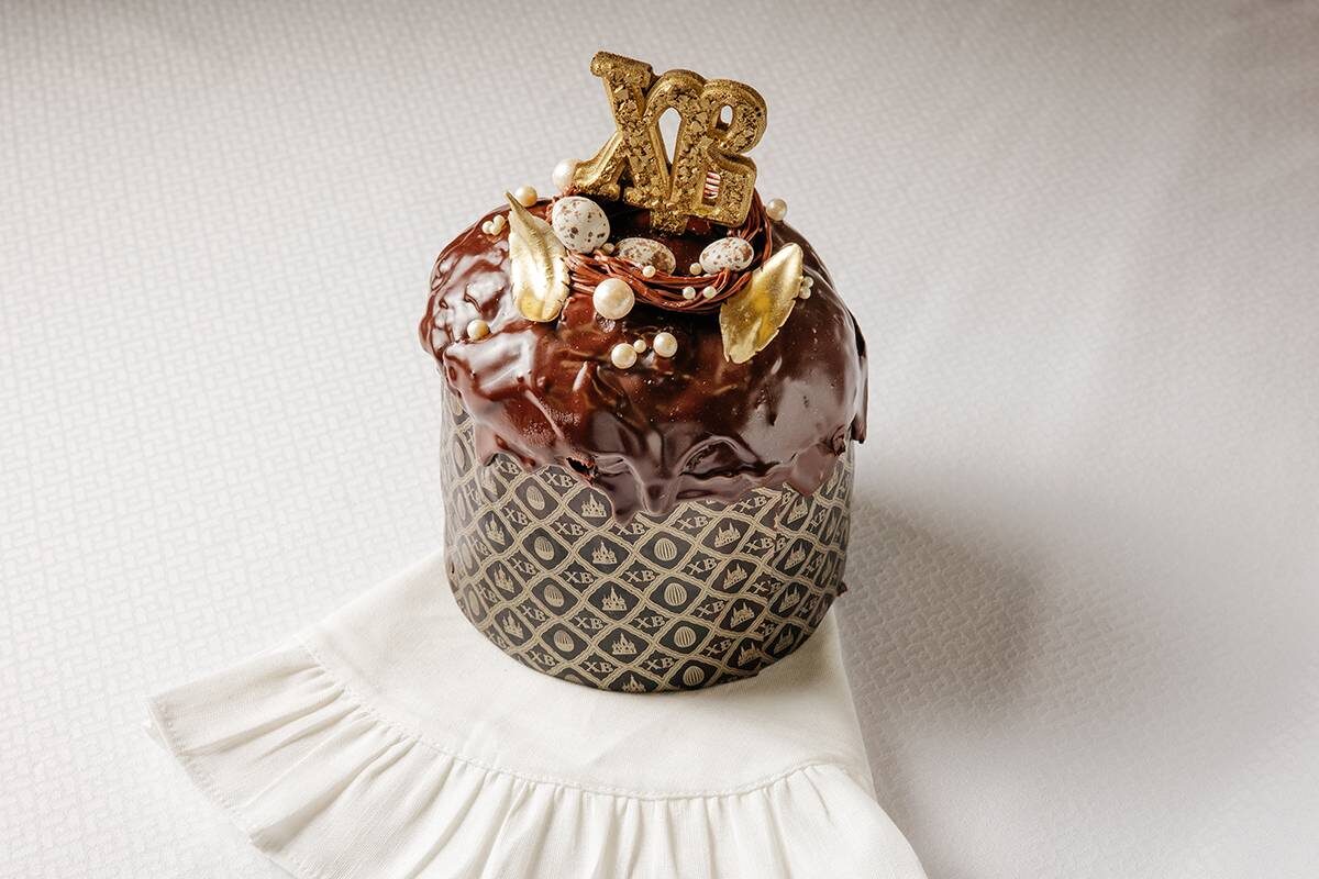 Шоколадный пасхальный кулич с буквами ХВ и золотым декором — современная альтернатива классической выпечке для праздничного стола.