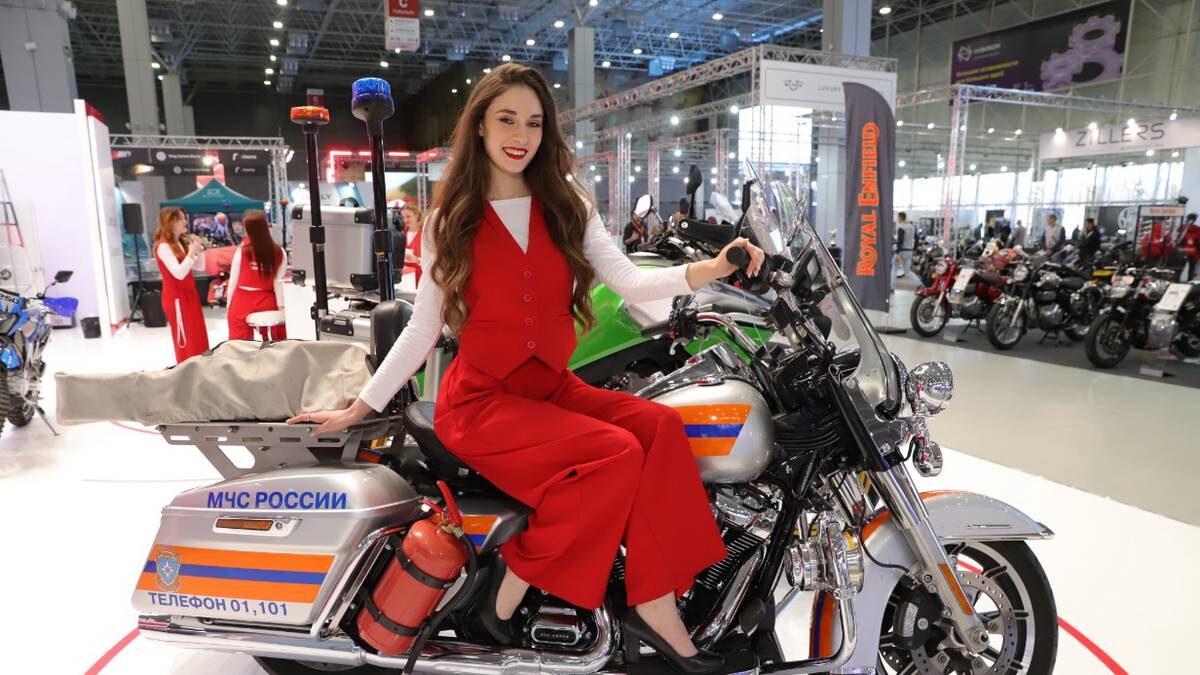    Промоутер Ариадна Бахметова у мотоцикла МЧС на фестивале «Мотовесна» / Фото: Анатолий Цымбалюк / Вечерняя Москва