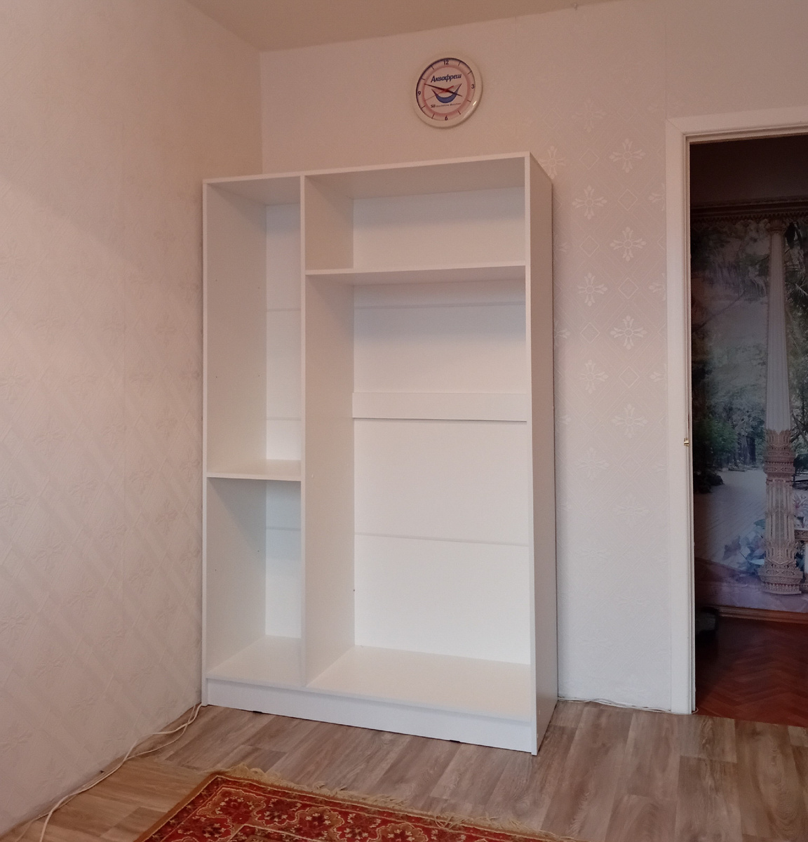 Легким движением рук поставили частично собранный шкаф на место. При вечернем освещении шкаф и обои выглядят розоватыми, на самом деле они белые.