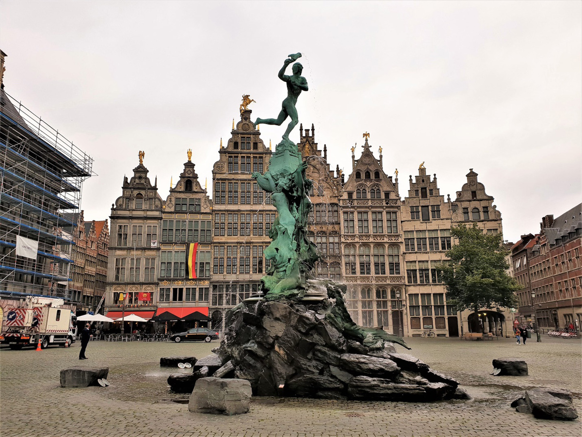 Центральная площадь Гроте Маркт. Один из главных символов Антверпена  (это крупнейший город и порт во Фландрии (Фламандском регионе) Бельги)— фонтан Брабо (1887). Согласно легенде, о мифическом великане Дрюоне Антигоне, жившем у моста через Шельду и бравшим плату за проезд, он отрывал руку тем, кто отказывался платить, и бросал её в воду. Но однажды великан был побеждён римским воином Сильвио Брабо, который отрубил ему руку и выбросил её в Шельду. Это событие предопределило название города. В переводе с нидерландского «hand werpen» — «бросать руку». Фонтан Брабо расположен перед ратушей Антверпена (на снимке слева в строительных лесах). Фото из открытых источников.