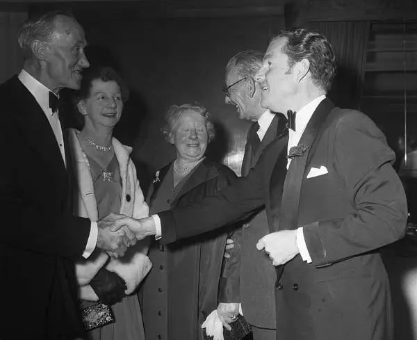 На премьере «Гибели "Титаника"» исполнитель одной из главных ролей в проекте Кеннет Мор (слева) пожимает руку С. Э. Дэниелсу, стюарду третьего класса на «Титанике»