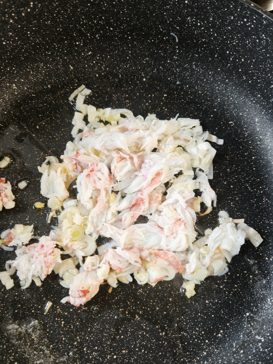Добавляем чищенное мясо краба.