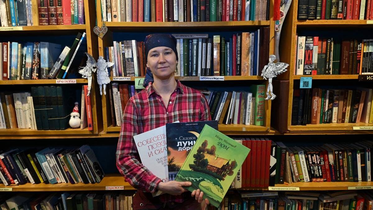   Основатель книжной барахолки Светлана Гусарова показывает свой ассортимент / Фото: Анатолий Цымбалюк / Вечерняя Москва