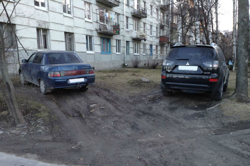 Машины, припаркованные на газоне возле жилого дома