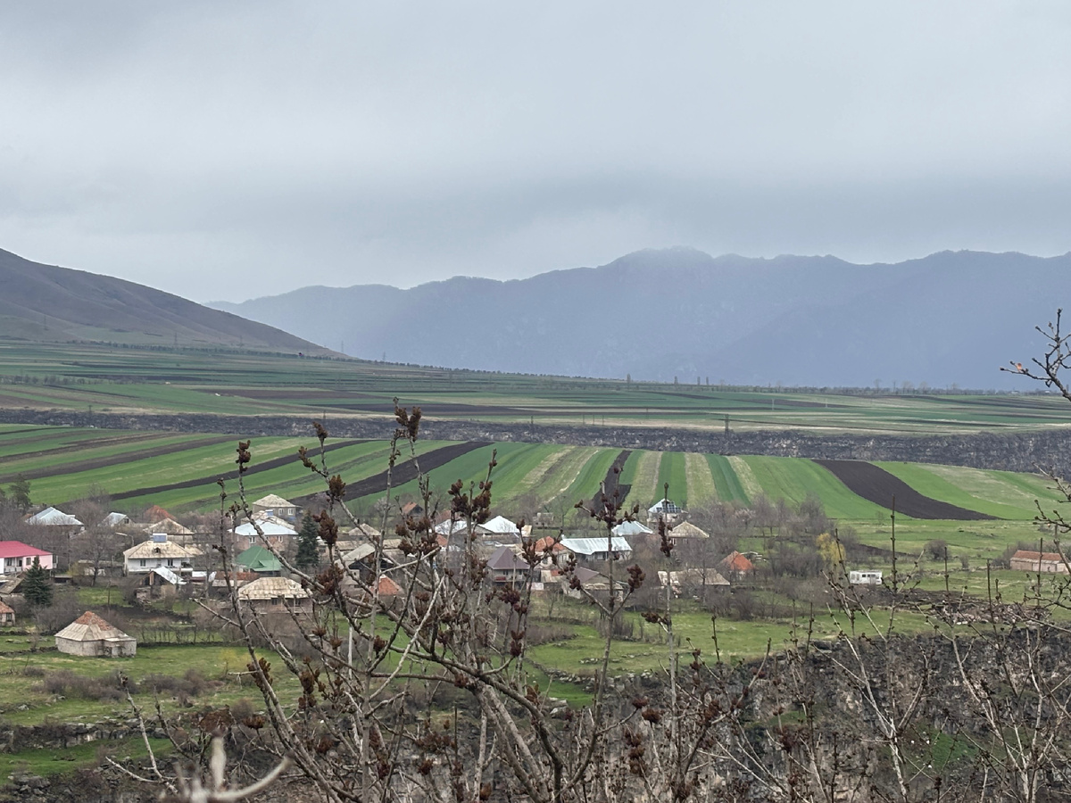 Куртан на краю ущелья и поля, уходящие в горы.