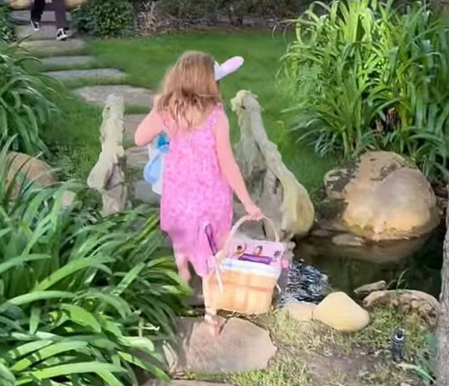 Лилибет носит кроличьи уши и несет корзину во время охоты за яйцами.