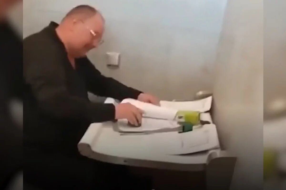    Бывший генерал-майор СБУ подделывает документы в туалете на заправке, ловко шлепая по бумагам поддельными печатями.