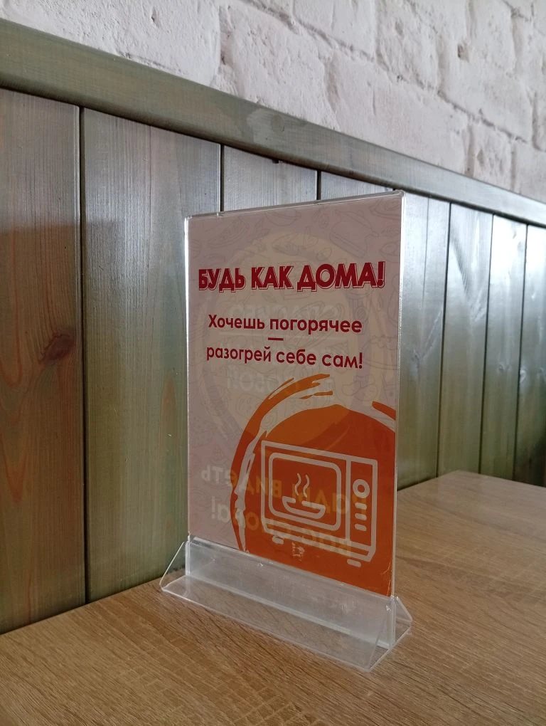 За одним из столиков.