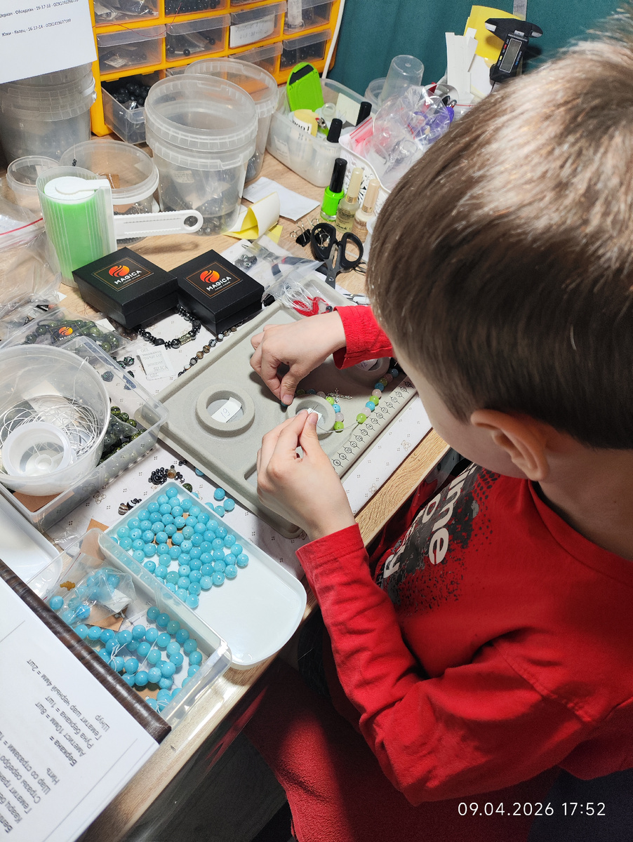 Миша в мастерской подбирает камни для браслетов 