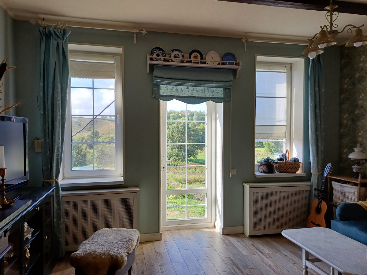 Римская штора висит в гостиной. Механизм расположен сразу под полкой с тарелочками. Фото автора