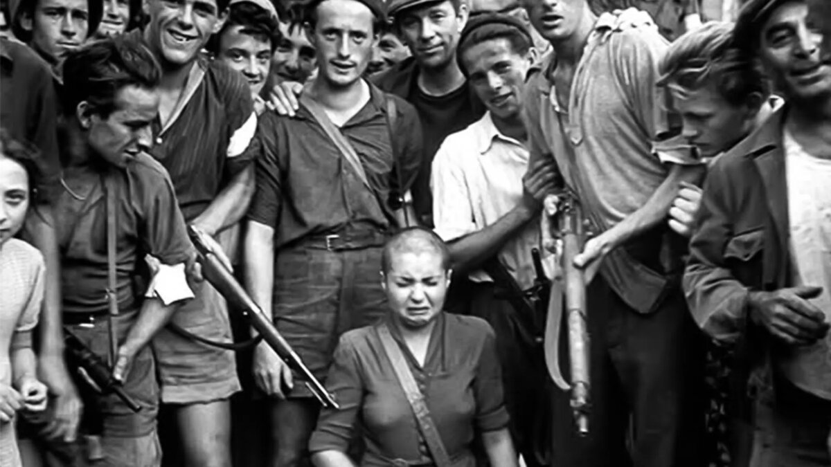 Женщина плачет после того, как ей обрили голову, а вооруженные мужчины толпятся вокруг нее, улыбаясь в камеру.