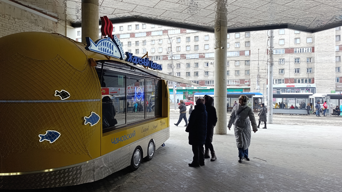 Фургон стоит в проходе между ТЦ и многоуровневой парковкой 
