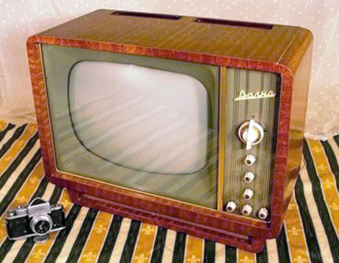 На снимке изображён телевизор «Волна» (ЗК-36), который с 1960 года выпускал Ленинградский завод им. Козицкого. Это чёрно-белый ламповый телевизор с деревянным корпусом, имитирующим ценные породы дерева. Основные ручки управления расположены спереди, остальные — с левой стороны в вертикальном ряду. 