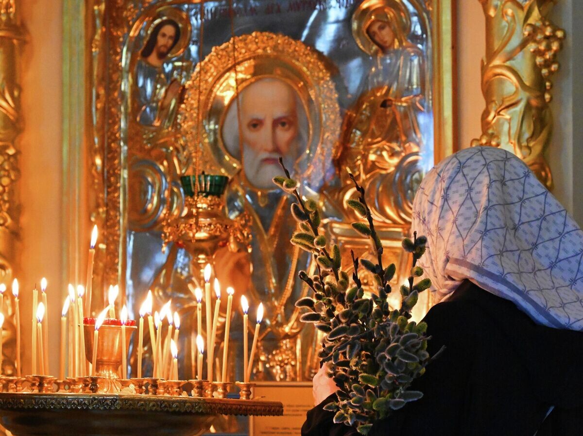    Верующая с букетом вербы в храме Успения Божией Матери в Успенском православном мужском монастыре в Красноярске | © РИА Новости / Илья Наймушин