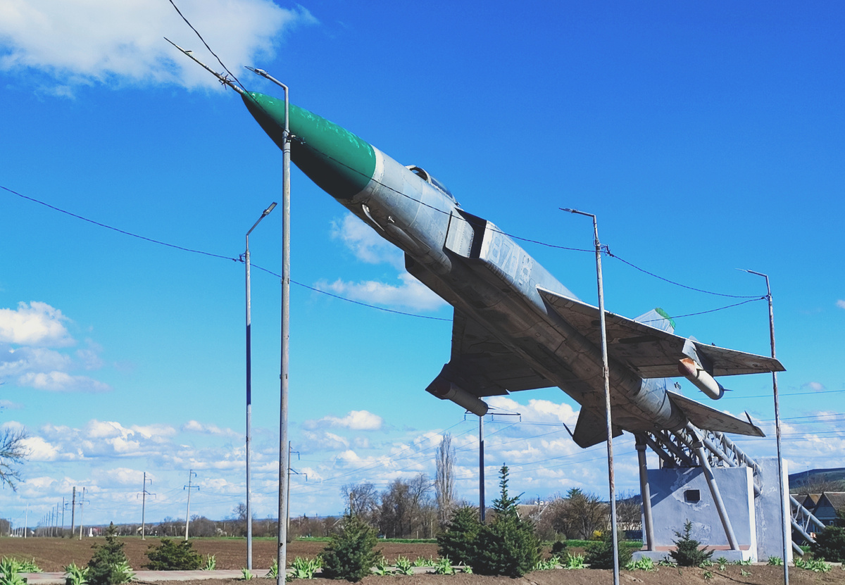 Из плохого - на опубликованных в сети фотографиях 2010-х годов отсутствуют эти ужасные столбы освещения, закрывающие собой красивейший самолёт. Хорошо конечно, что кто-то подумал и реализовал освещение памятнику, но вот пара направленных прожекторов слева/справа дающие освещение вверх - на самолёт, а также небольшой прожектор у двигателей, освещающий сверху постамент с мемориальной табличкой, и освещали бы эту экспозицию куда как интереснее, и внешне ничего бы не загромождали. 