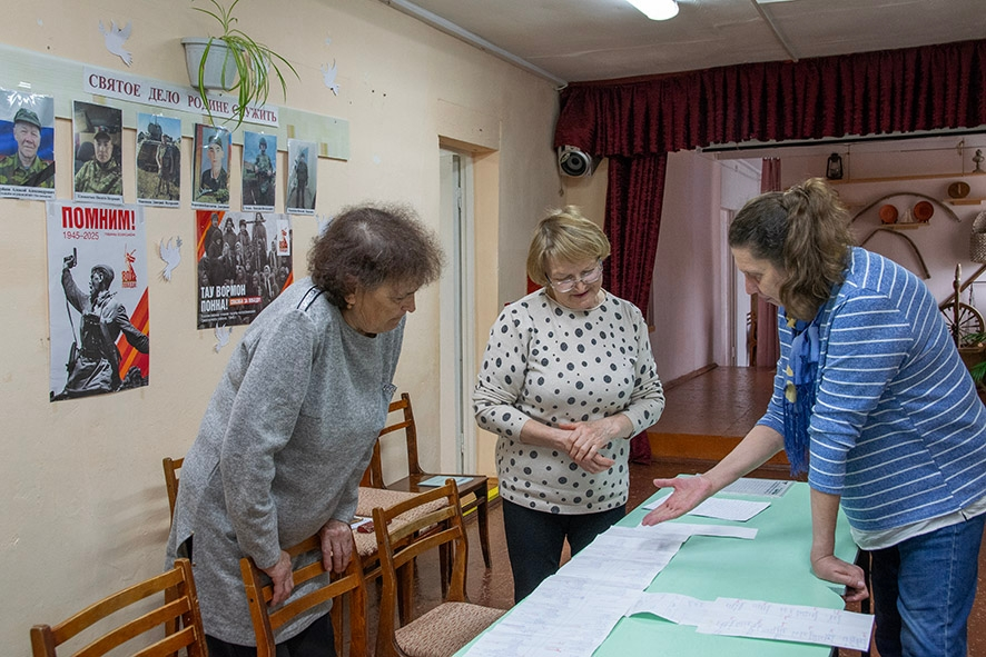 Галина Вениаминовна Ившина, Галина Дмитриевна Ившина и Вера Геоленовна Болдырева изучают «карту» Кузьмовыра с улицами, составленную одной из жительниц деревни