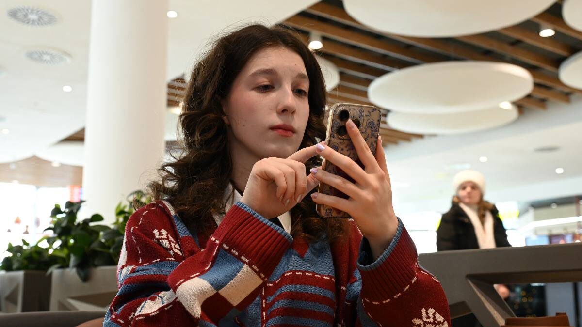    Студентка МГУТУ имени Разумовского Елизавета Степанова со смартфоном в районном центре «Киргизия» / Фото: Анатолий Цымбалюк / Вечерняя Москва