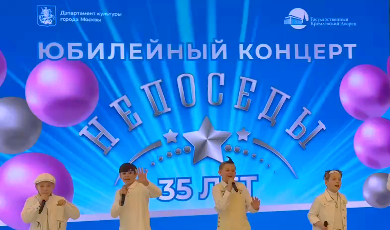 В фойе на фоне афиши дети пели для собирающихся зрителей.