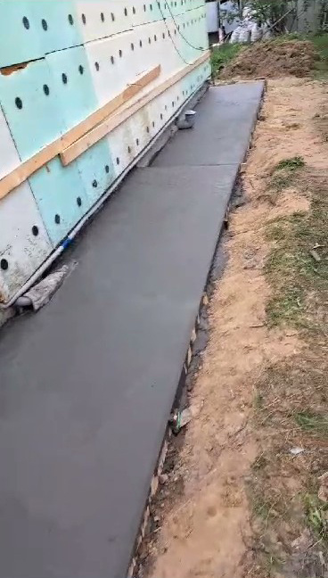 Утепленный полистиролом дом с залитой отмосткой.