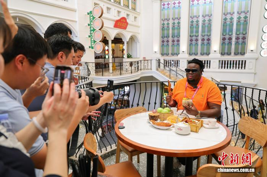 13 апреля нигерийская телеведущая Олвавабунми Генри Джимох рекламировала хайнаньский чай «Лао Ба Ча» (местный бренд чая) онлайн-зрителям на хайнаньском диалекте в магазине «Йечэн Силу Лао Ба Ча» на старой улице Цилоу в Хайкоу. (Фото: Ло Юньфэй, Китайская служба новостей) 4月13日，尼日利亚籍主播博密(OLUWABUNMI　HENRY　JIMOH)在海口骑楼老街的椰城喜鹿老爸茶店里，用海南话向网友推介海南老爸茶。中新网记者 骆云飞 摄