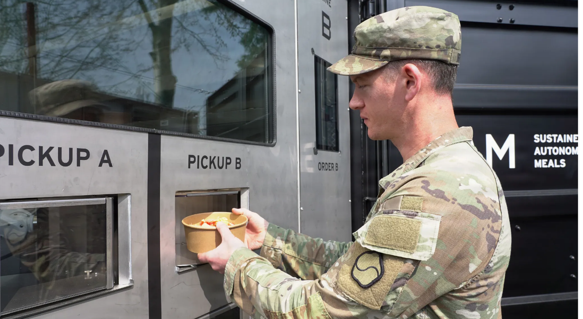 Сотрудник службы питания 19-го экспедиционного командования материально-технического обеспечения забирает приготовленное питание из системы автономного питания (SAM) в лагере Уокер, Южная Корея