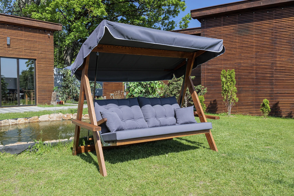 Трехместные качели Lyon на деревянном каркасе вписываются в природный ландшафт участка. Обивка из олефина не впитывает влагу. Код для поиска на сайте — 903813.