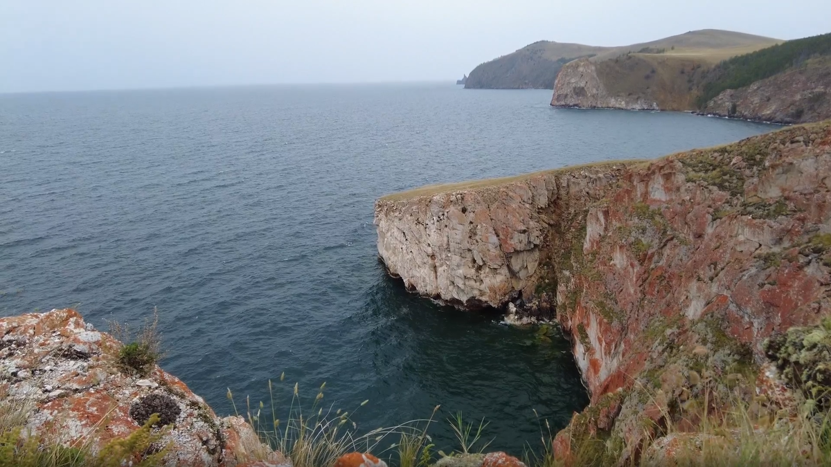 Величие байкальских берегов: отвесные скалы Ольхона, покрытые ярким рыжим лишайником, обрываются прямо в бездонную синеву. Здесь, на краю острова, ощущаешь истинную мощь и спокойствие священного моря