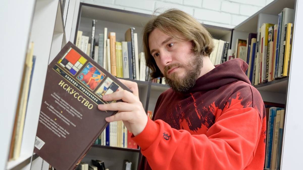    Кирилл Марков с интересом разглядывает книги на полках в библиотеке имени Лермонтова / Фото: Дмитрий Дубинский / Вечерняя Москва