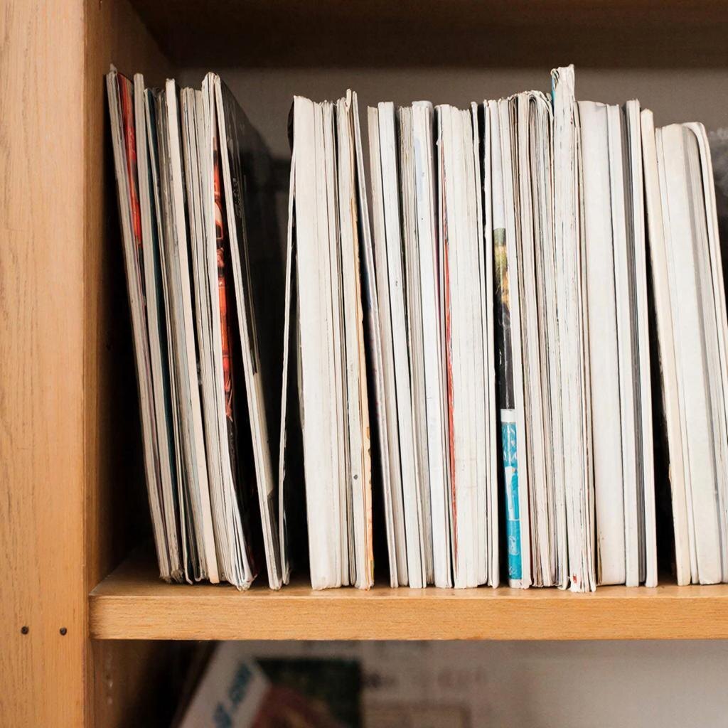 Стопка старых журналов на полке