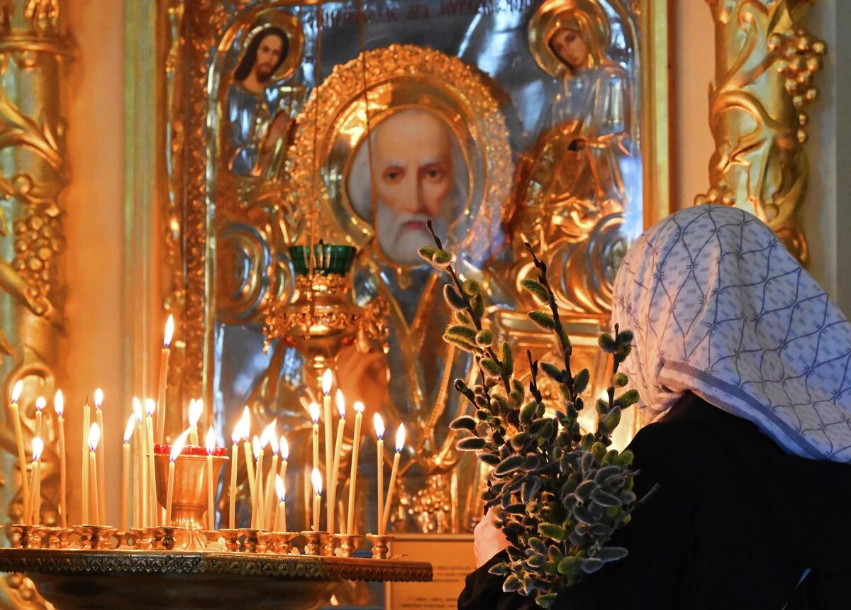 Верующая с букетом вербы в храме Успения Божией Матери в Успенском православном мужском монастыре в Красноярске | © РИА Новости / Илья Наймушин