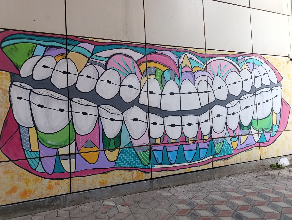 Весёлое графитти на стене частной стоматологии.