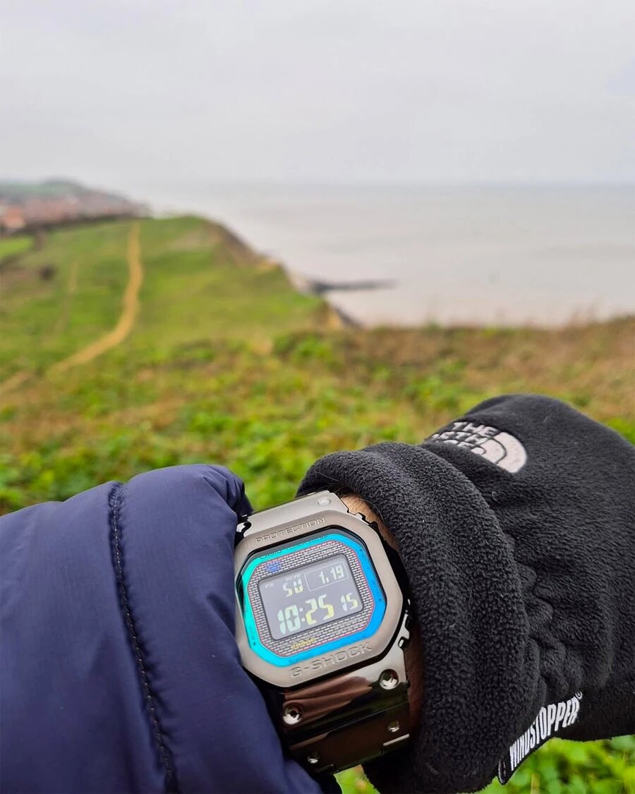 Рамка циферблата G-Shock GMW-B5000BPC-1E постоянно меняет цвет в зависимости от освещенности и угла зрения — вы увидите это на следующих фото