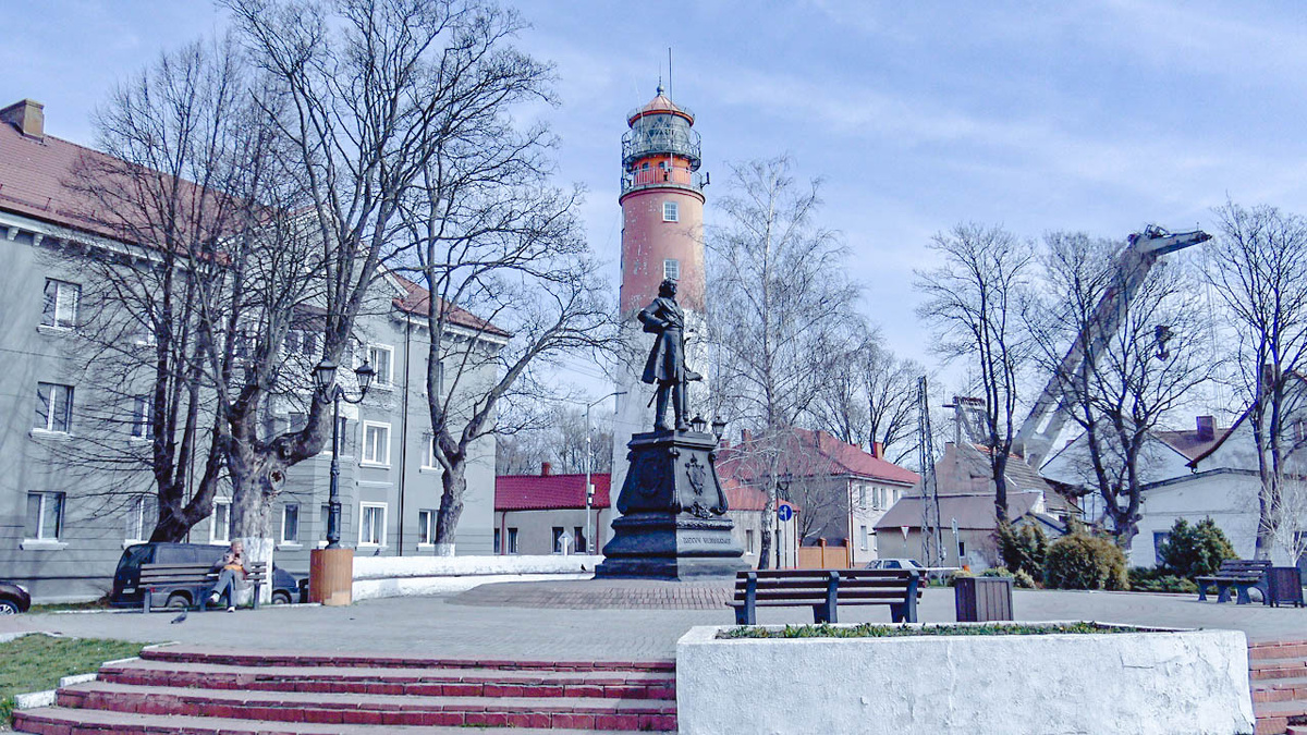 Снимок с точки, где виден и маяк и памятник Петру I. В этот раз повезло: в кадр попала стрела портового крана