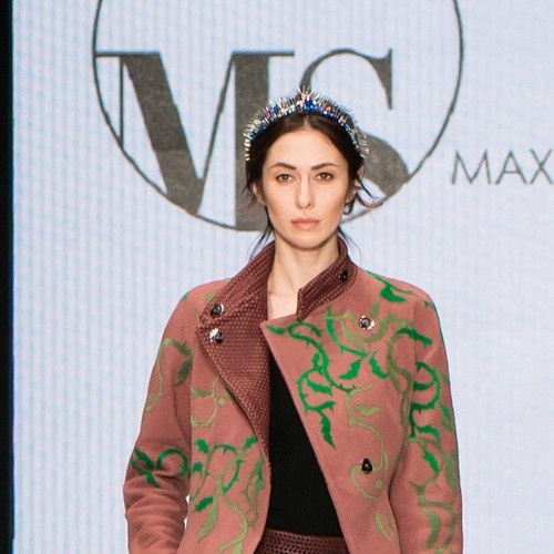 FashionTime Designers — показ молодых российских мастеров  
Модель в пальто с зелёным флористическим узором и декоративными пуговицами. Отличный вариант для финального фото или atmospheric‑блока.