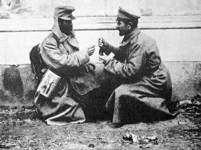 Австрийский (слева) и русский (справа) солдаты обмениваются папиросами во время Первой мировой войны