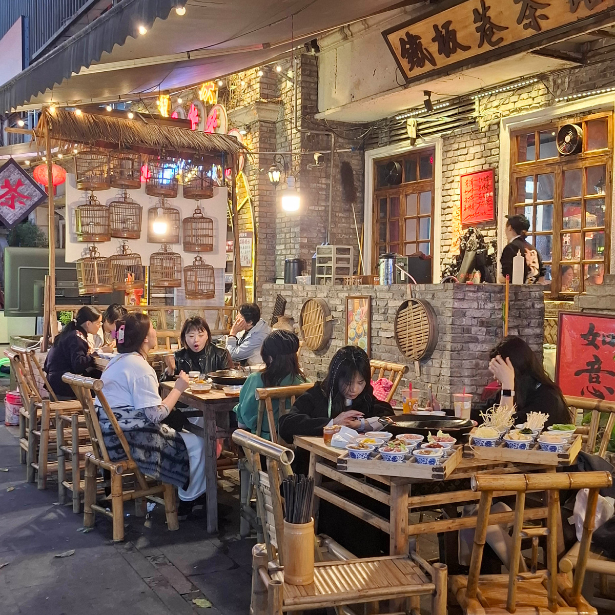 В центре столов - «китайский самовар», в маленьких тарелочках всё, что они собираются себе приготовить. Фото автора, сделано в Чунцине.