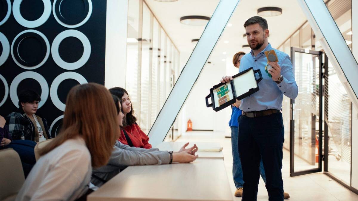    Один из разработчиков спутника, заместитель директора Института радиотехники и информатики РТУ МИРЭА Святослав Литвинов показывает студентам детали, используемые в аппарате / Фото: Пресс-служба РТУ МИРЭА