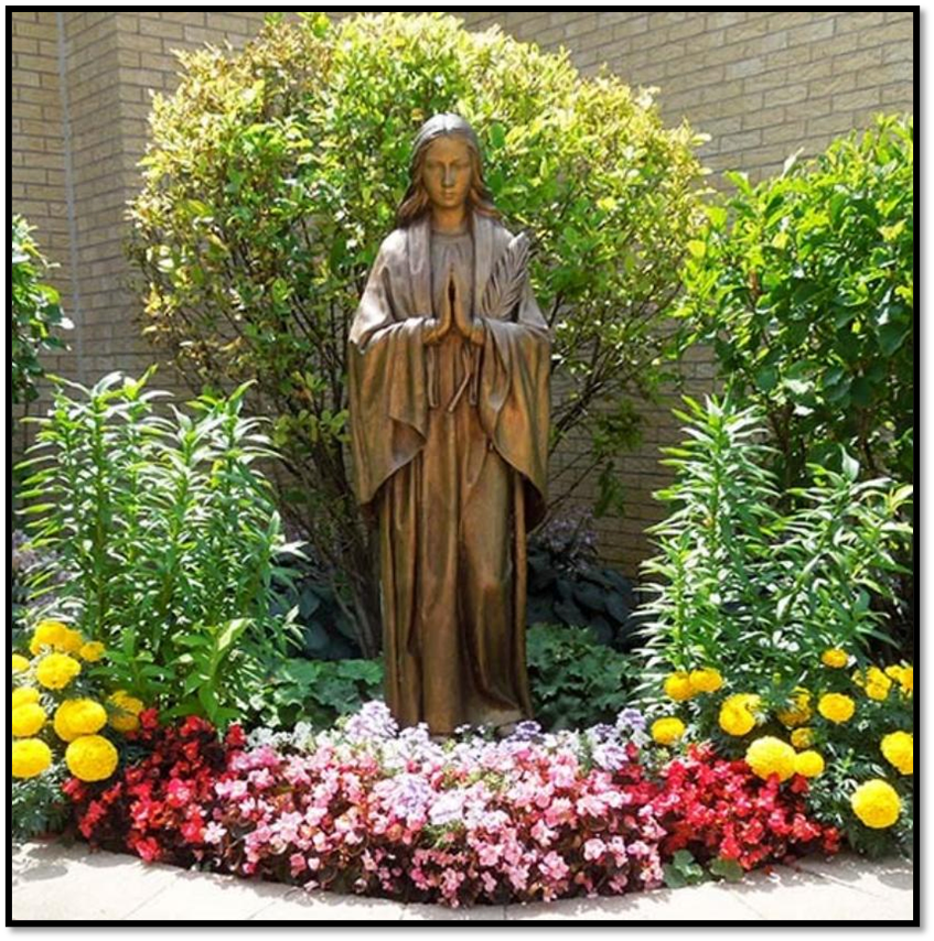 статуя Пречистой Девы Марии, окруженная цветами и декоративными растениями. Фото из интернета